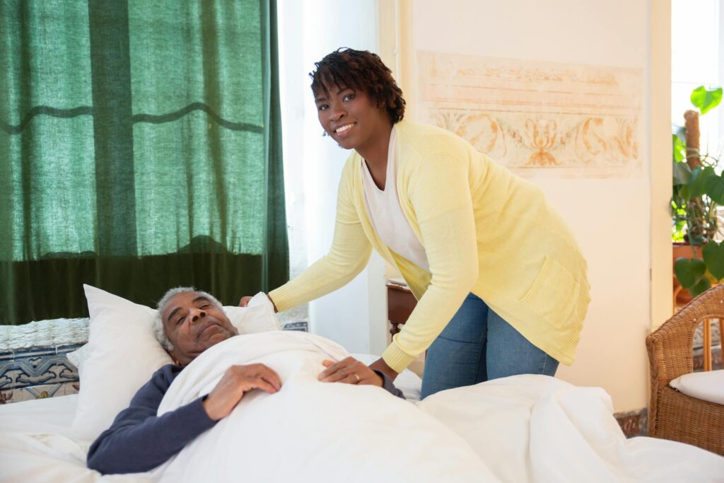 Care Services A woman tending to an elderly man in a bright and warm bedroom, symbolizing care and family support.