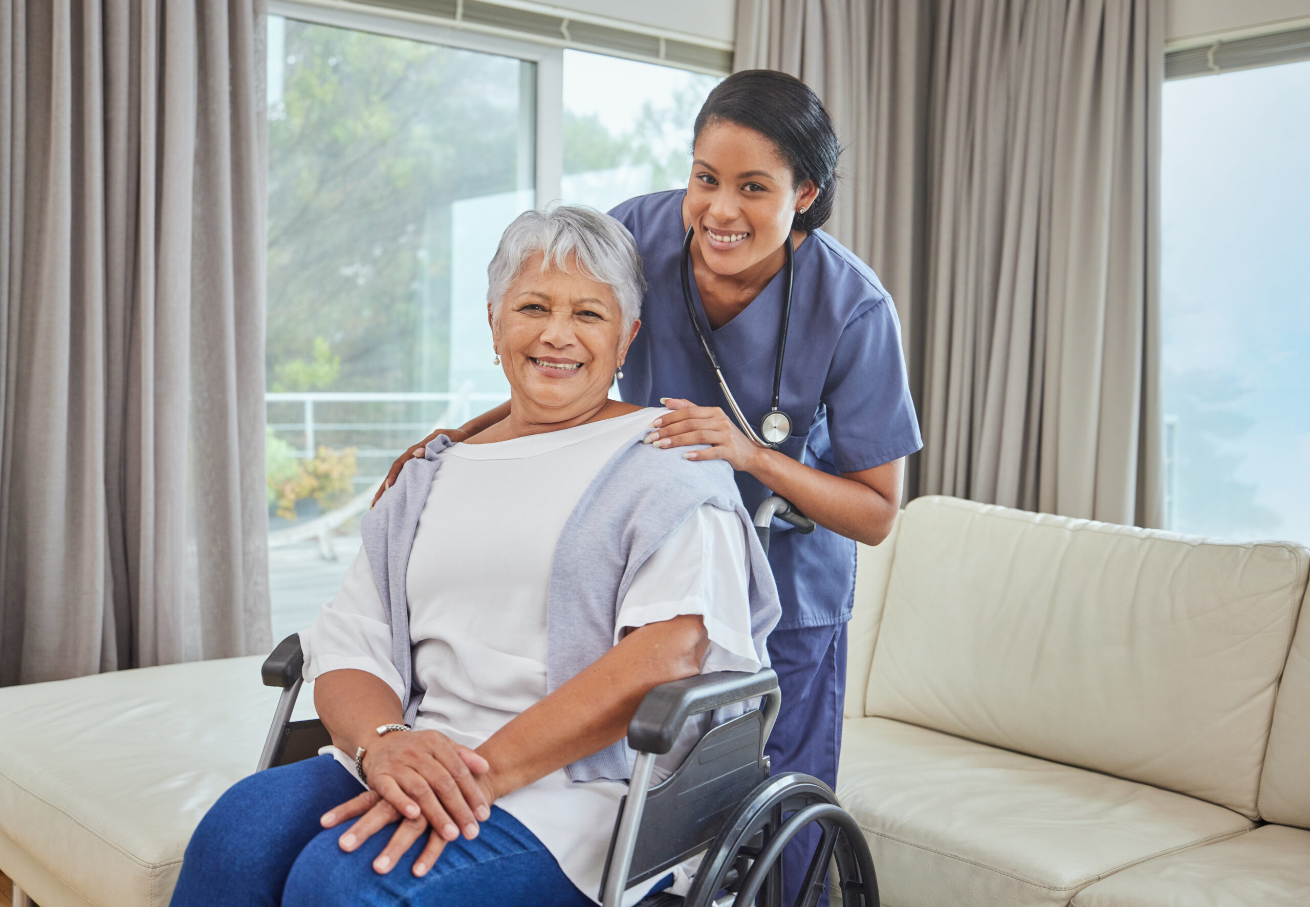 Home portrait of a hispanic senior woman in a wheelchair and her female nurse in the old age home. mixed race young nurse and her patient in the lounge