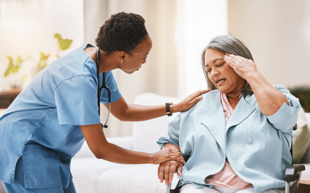 Care Services nurse, senior woman and headache with rehabilitation, physiotherapy and help with disability. black woman, healthcare expert and old woman for injury, wellness and physical therapy for helping hand