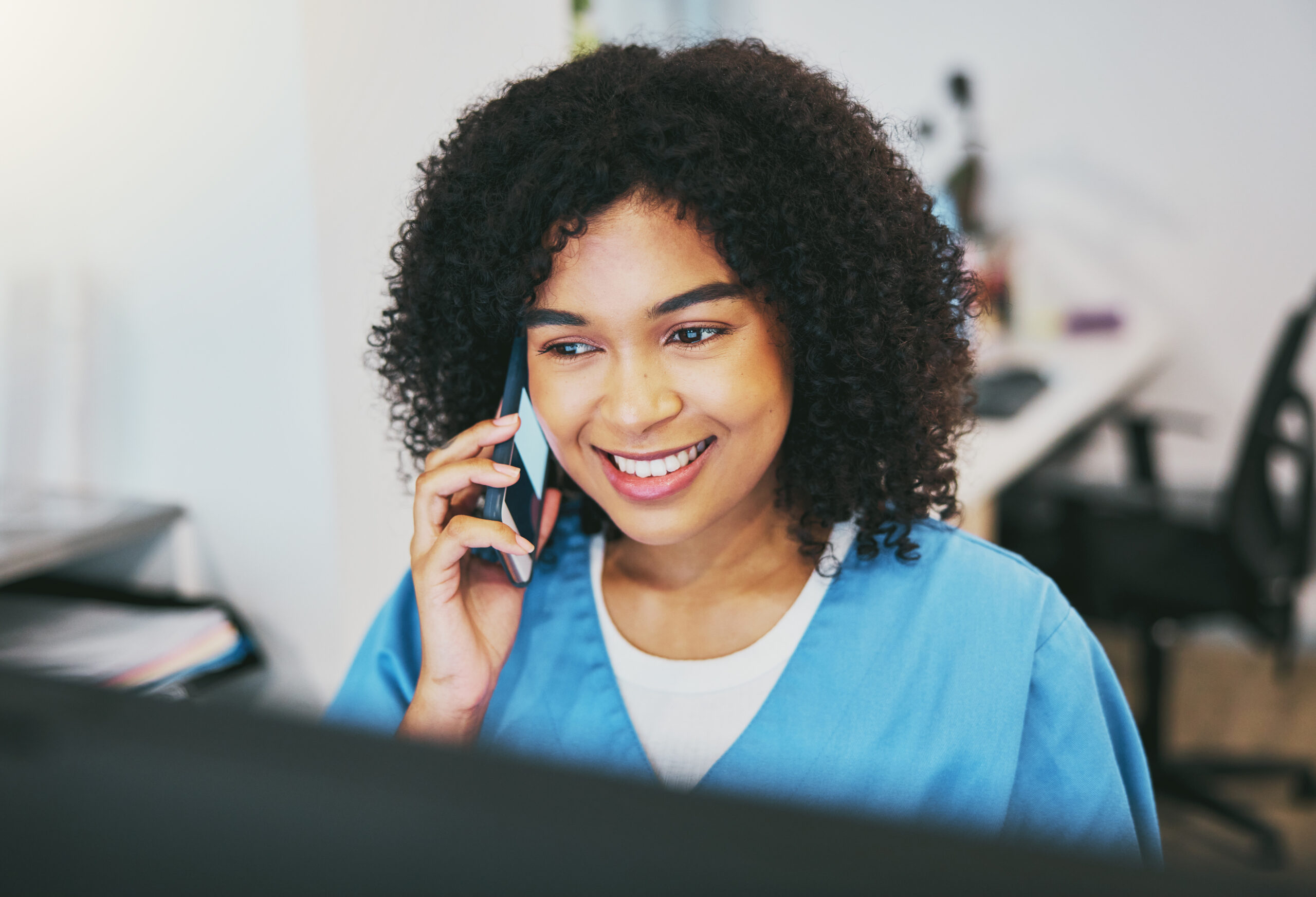 Contact Us phone call, happy and woman nurse in the hospital working on a computer for medical reports. healthcare, technology and professional african female doctor on a mobile conversation in medicare clinic.